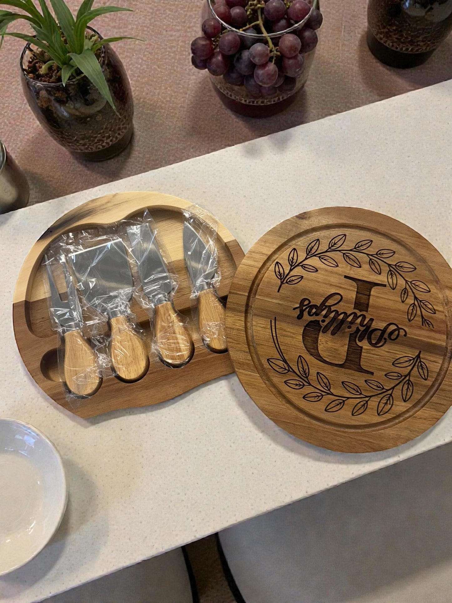 “Round acacia wood cheese board with knife set stored inside”