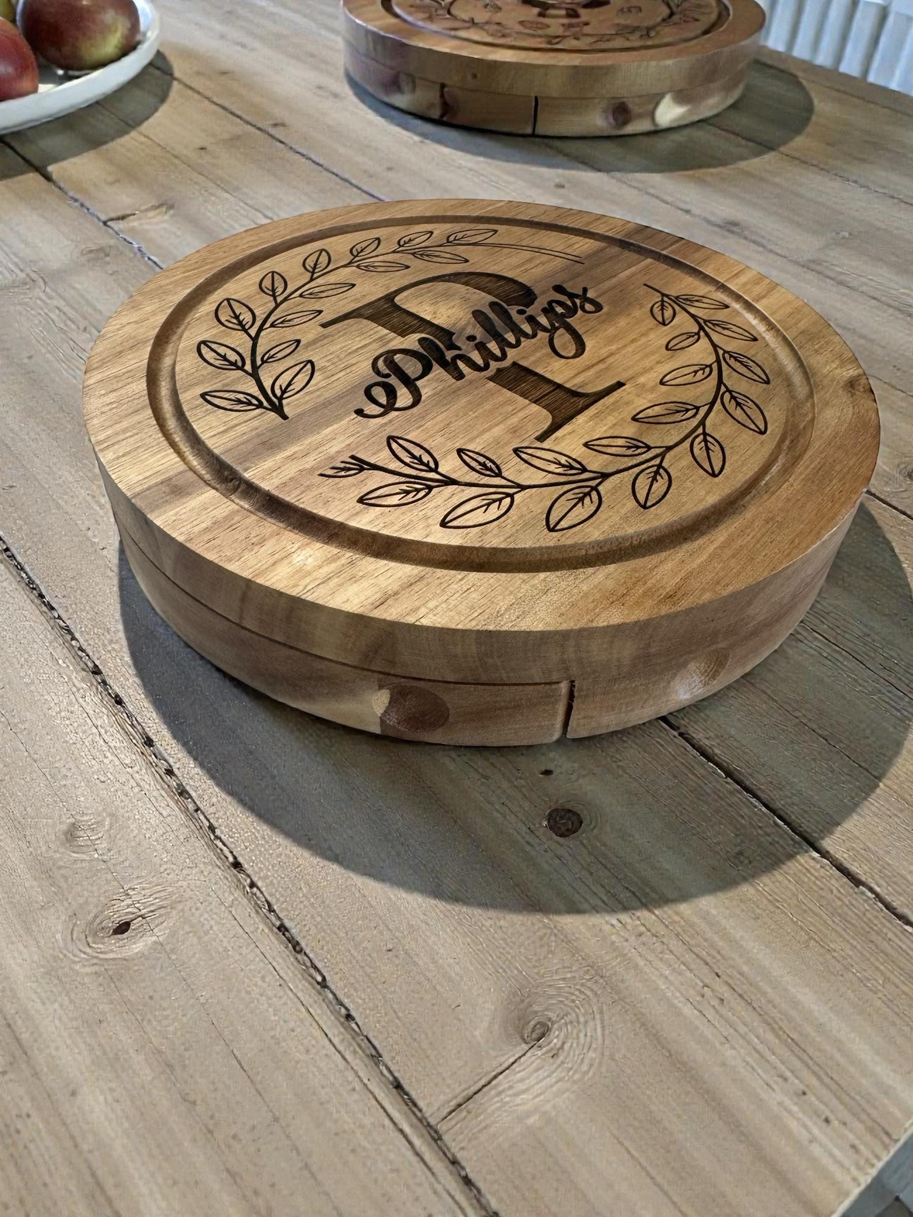 “Side view of round acacia wood serving board with engraved design”